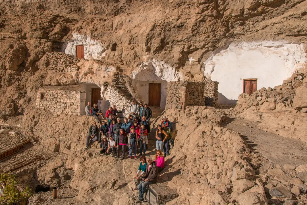 Visitors among cave houses at Acusa Seca