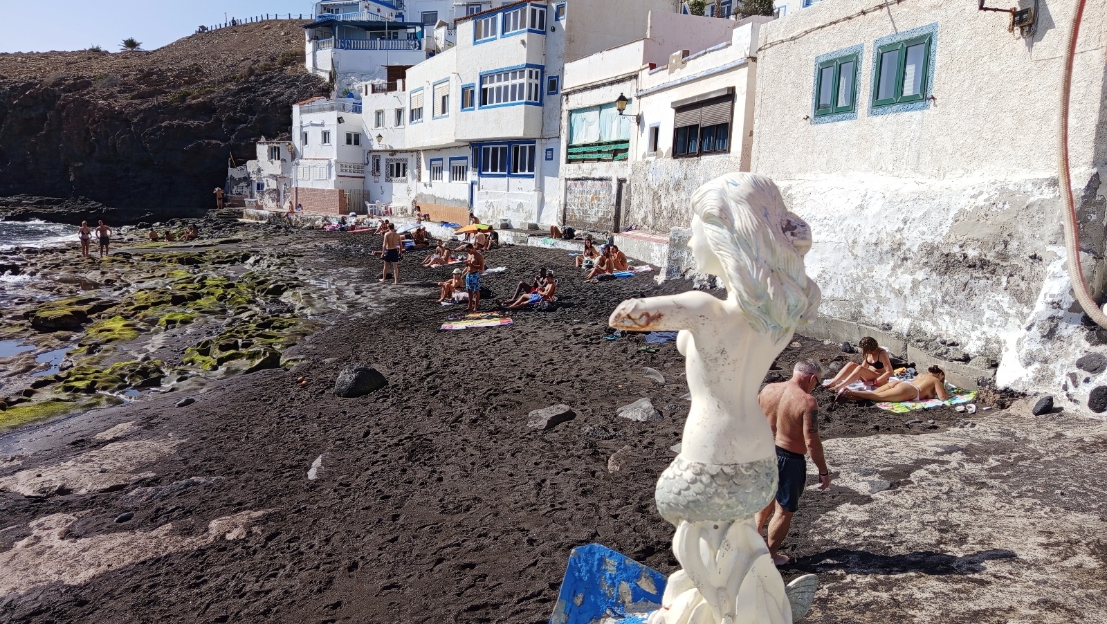 Tufia beach with mermaid statue and black sand